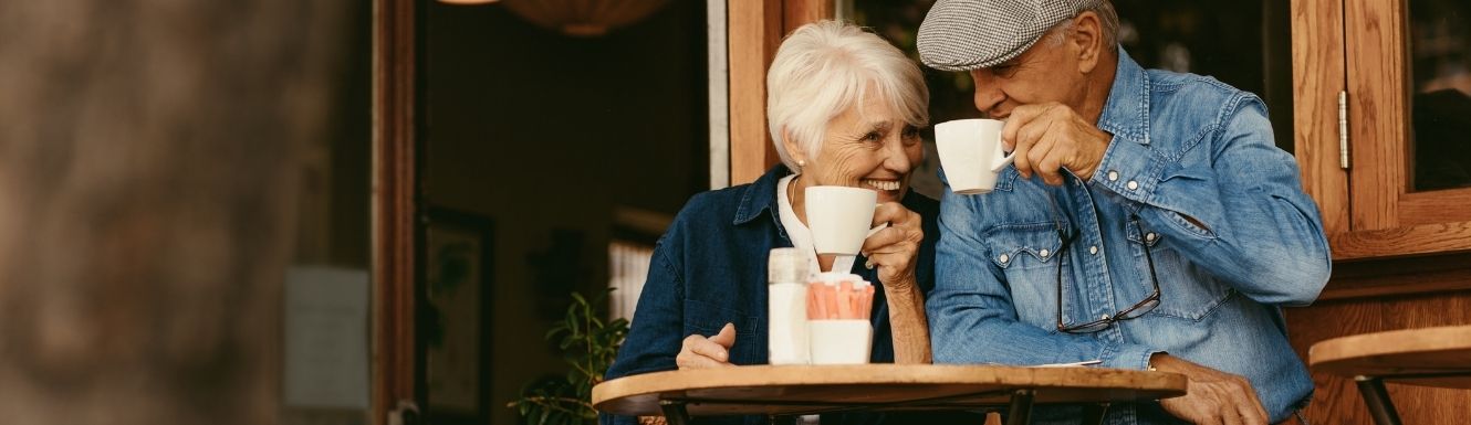 mature retired couple enjoying coffee outside a coffee shop