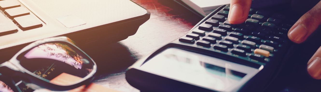 calculator on a desktop next to a pair of sunglasses