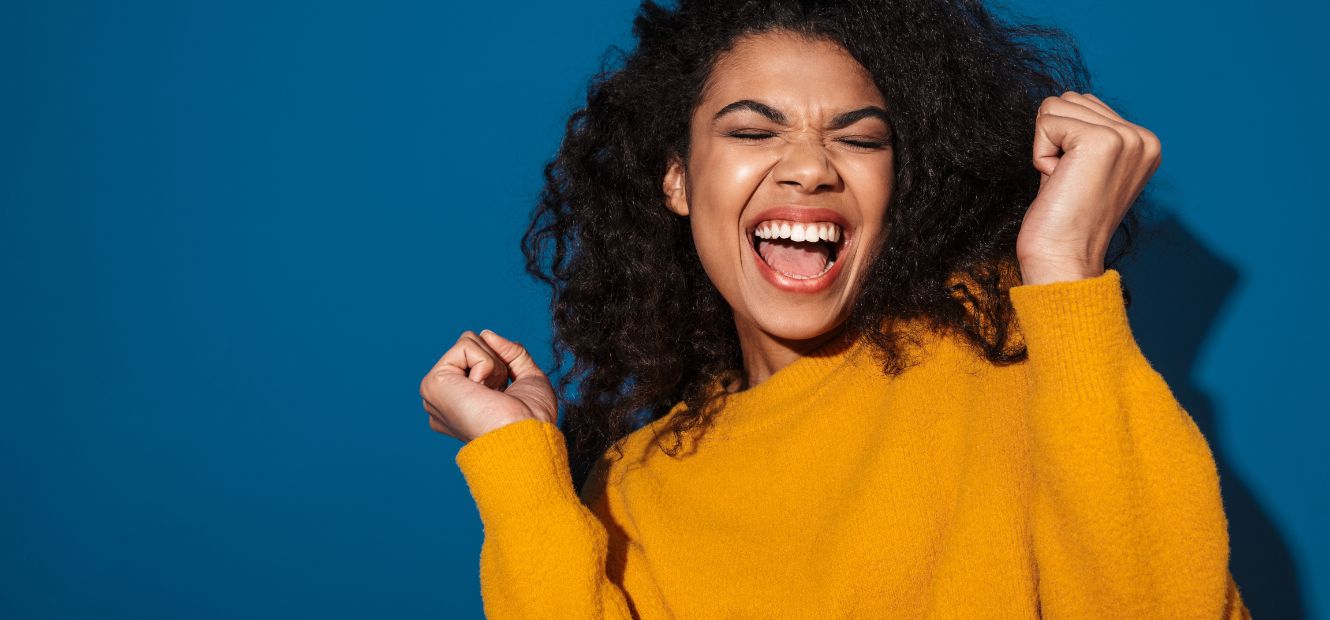 image of a young excited cheerful woman posing isolated over blue wall background