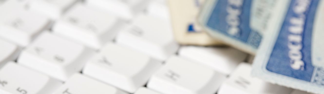 blurred social security cards sitting on white keyboard