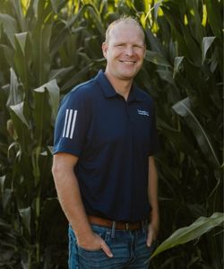 Ryan Groteluschen, Vice President standing in front of corn stalks