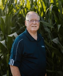 Bryan Trimble, Ansley Branch Manager, standing in front of cornstalks