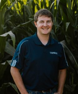 Joe Hickman, Loan Officer, standing in front of cornstalks