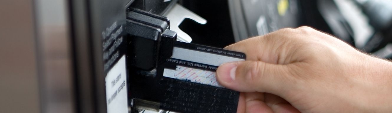 Person inserting debit card into a gas station card reader