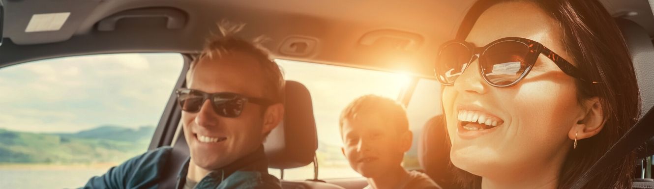smiling family in car with sun shining brightly