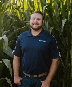 Joe Libal, Assistant Vice President, standing in front of cornstalks