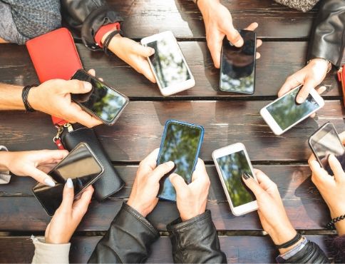 Many hands in a circle holding cell phones