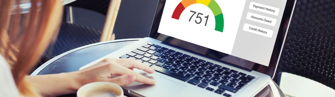Person looking at laptop screen showing a credit score of 751