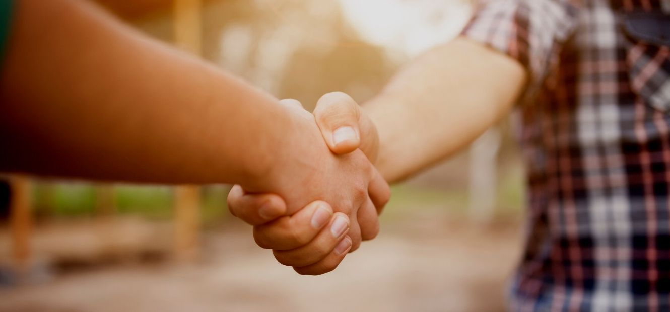 two people shaking hands outside