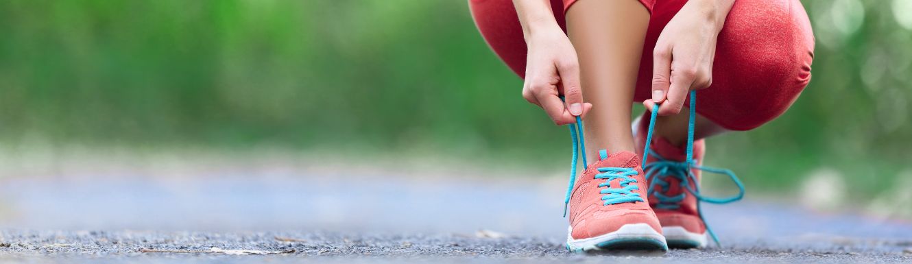 runner lacing up shoes on pavement